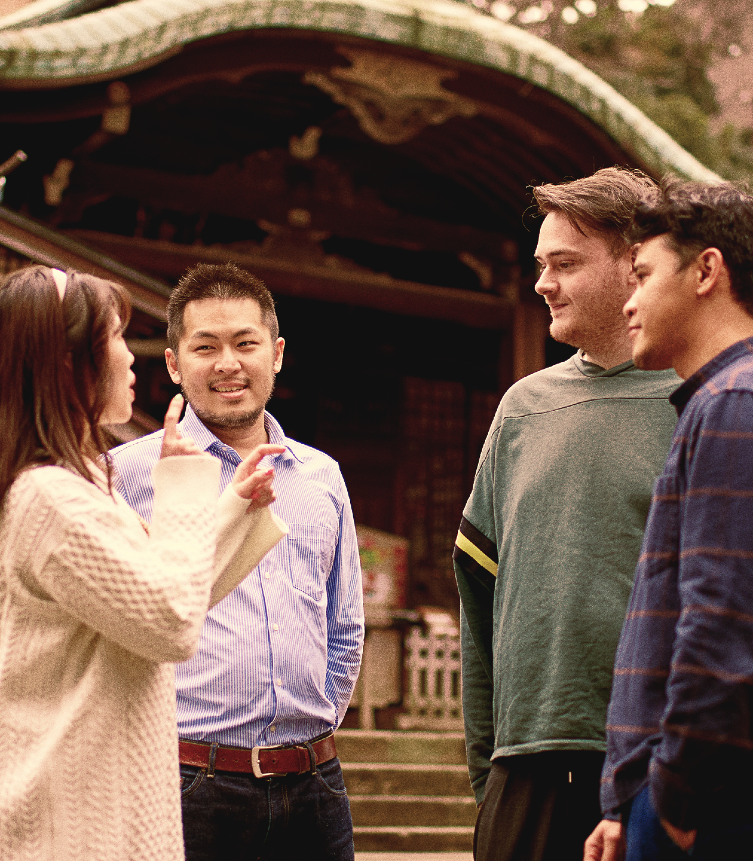 A diverse group of people having a discussion in a Japanese shrine