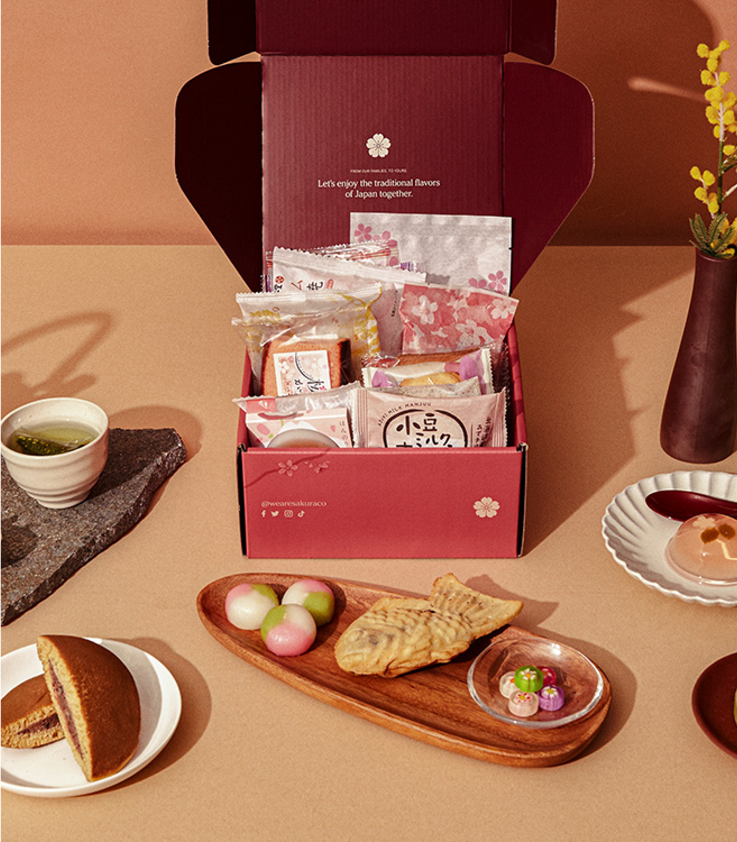 An open Sakuraco Japanese subscription box behind authentic Japanese sweets.