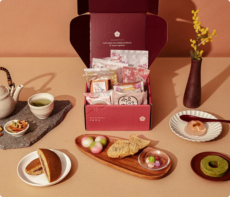An open Sakuraco Japanese subscription box behind authentic Japanese sweets.